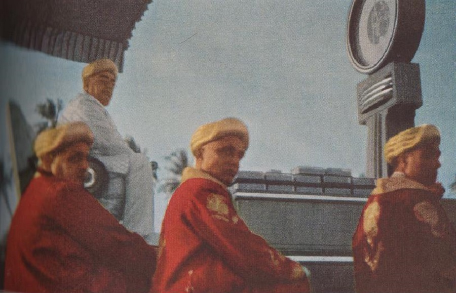 Bulletproof caskets of transparent plastic rest on the scale. These contain industrial diamonds on loan from London for the weighing. The setting was Dar es Salaam, Tanganyika, East Africa, a stronghold of the Ismailis. Scarlet-robed members of the Aga Khan Legion surround the Imam. Photo: National Geographic, March 1947