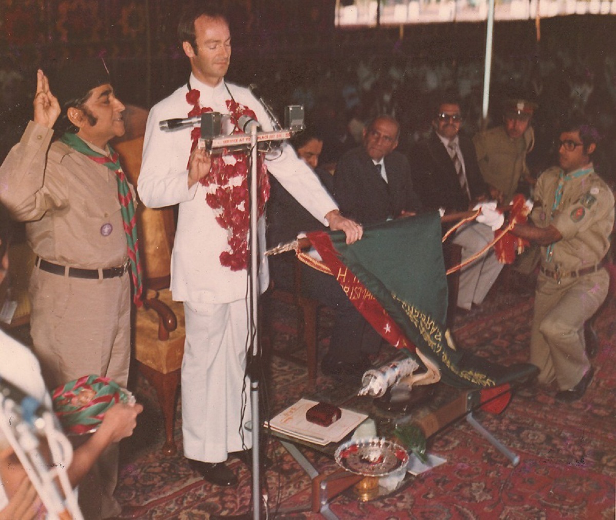 Vazir Sherali Alidina, President of the Scouting Association, left, was in charge of conducting the investiture ceremony, which began with Prince Amyn Mohamed Aga Khan reciting the Scout Promise with his left hand on the flag of the Ismaili Scouts Association and his right hand raised in half salute. The President then wrapped the Scout Scarf on Prince Amyn Mohamed’s nape, and pinned the scout badge on his left pocket completing the task with a left-handed scout hand shake with the Prince; the Prince now officially became the second Chief Scout of the Ismailis, following his late father, Prince Aly Khan, who was the first Chief Scout of the Ismailis. The dignified ceremony was short and lasted fifteen minutes. Photo: Khizar Hayat Collection, Toronto, Canada.