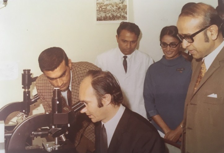 Aga Khan looking through microscope