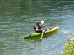 A person kayaking on a calm river.