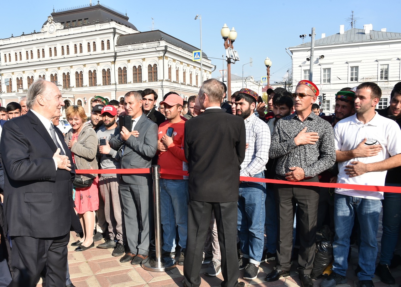 Aga Khan IV interacts with a crowd of supporters during a public appearance, with people visibly engaged and greeting him warmly.