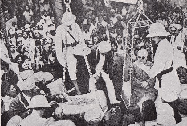 Historical image showing a public event where individuals are weighed on scales, surrounded by a large crowd observing the proceedings.